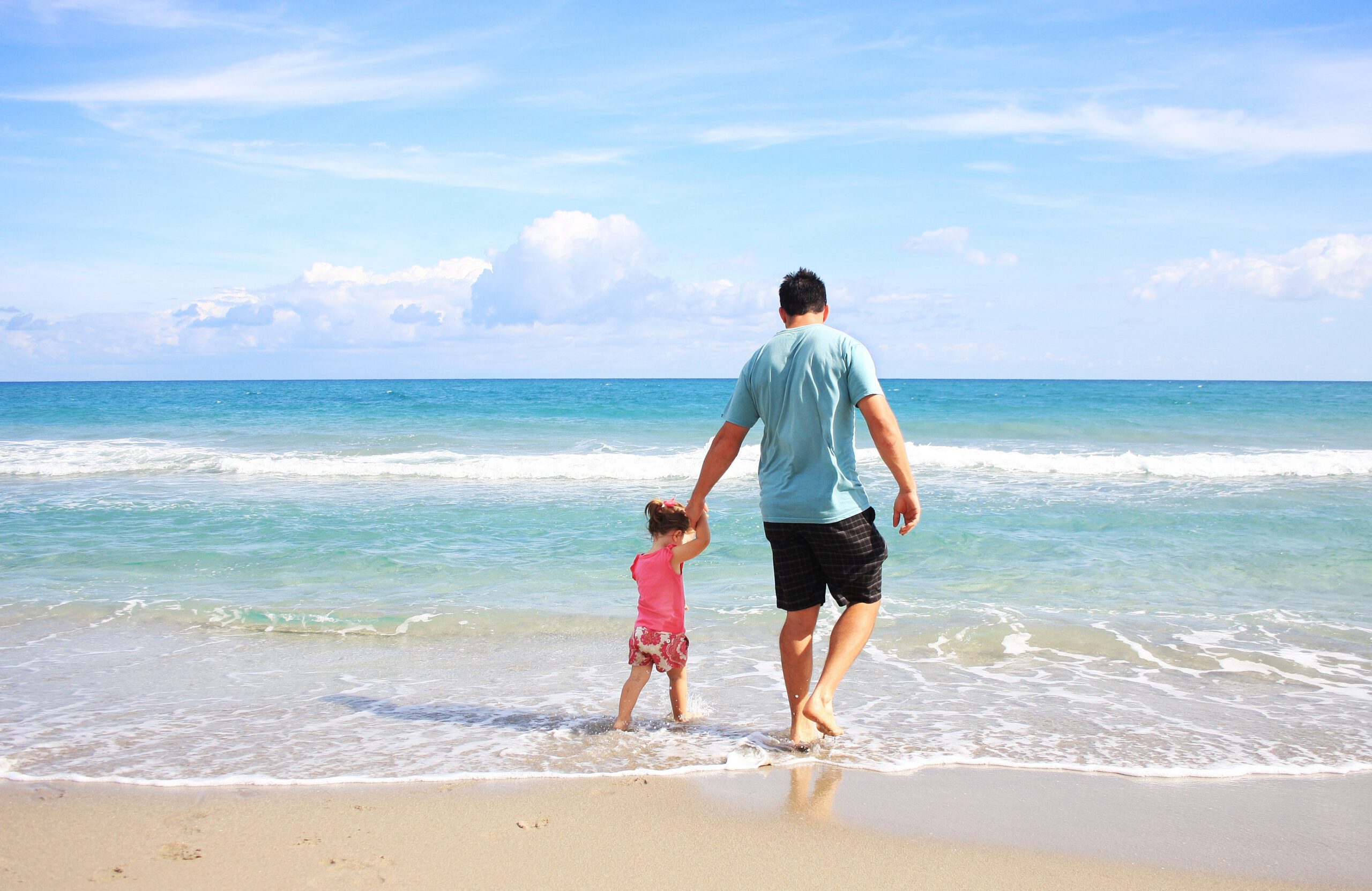 Tato na urlopie ojcowskim spędzający czas z dzieckiem nad morzem